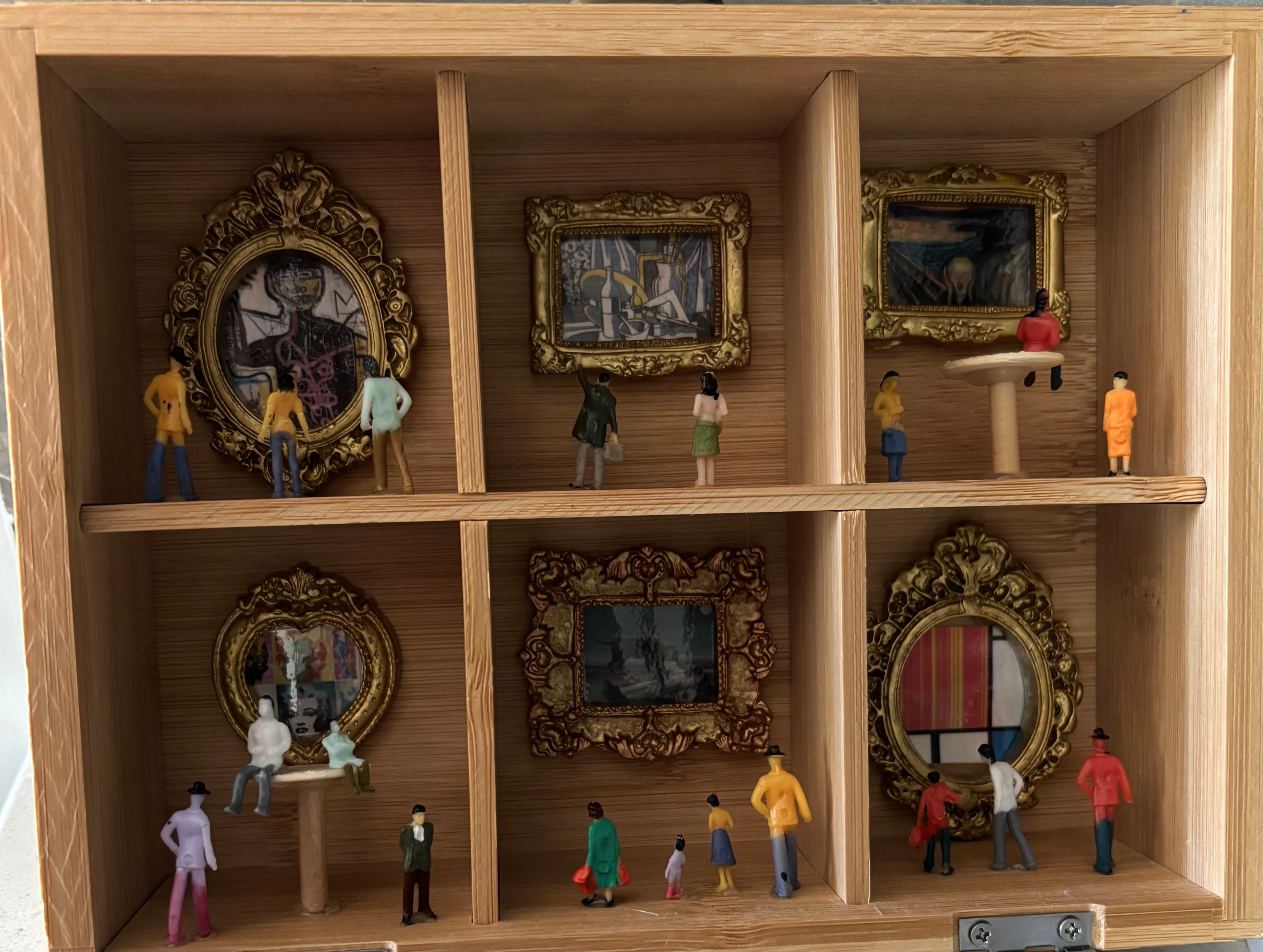 Small wooden display case with six miniature framed paintings and tiny figurines observing them, arranged in two rows.
