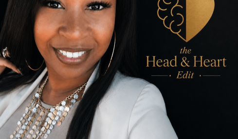 A woman with long black hair smiling, wearing a white blazer and layered necklaces, standing next to a logo with a brain and heart, on a black background.