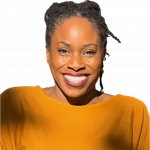 Smiling woman with braided hair wearing a mustard yellow top, facing forward, against a black background.