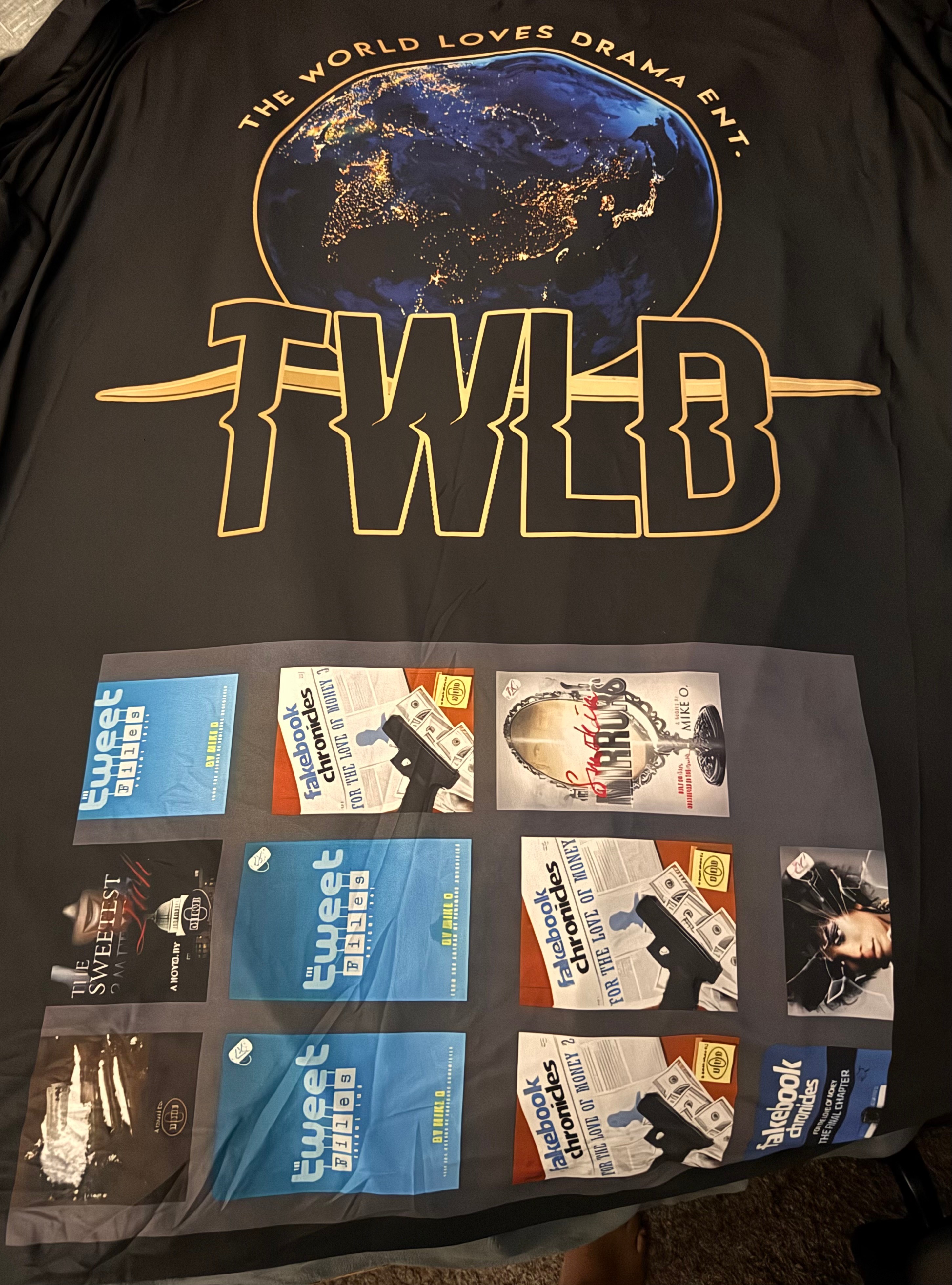 Black shirt with a globe and text, featuring six event tickets at the bottom, and a logo reading 'TWLD'.