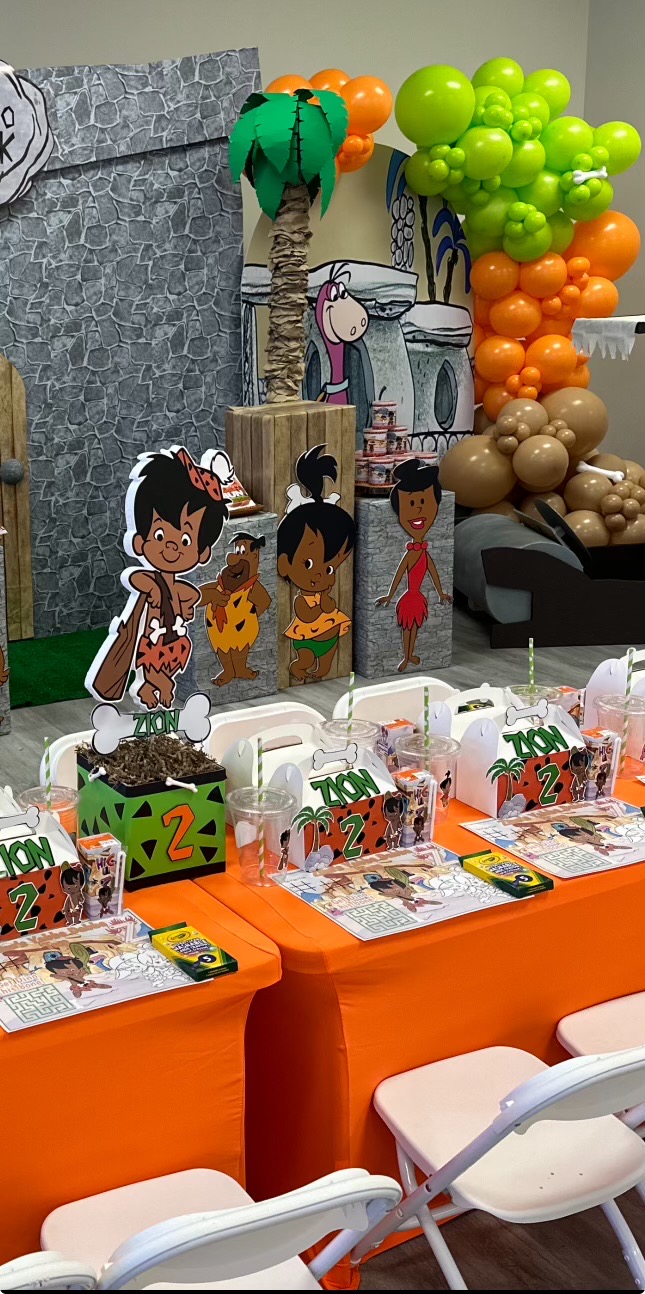 Party decorations with cartoon characters, balloons, and tables with party favors, set in an indoor space.