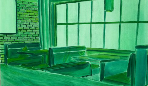 Interior of a room with green-toned furniture, large window, brick wall, and hanging light fixture.
