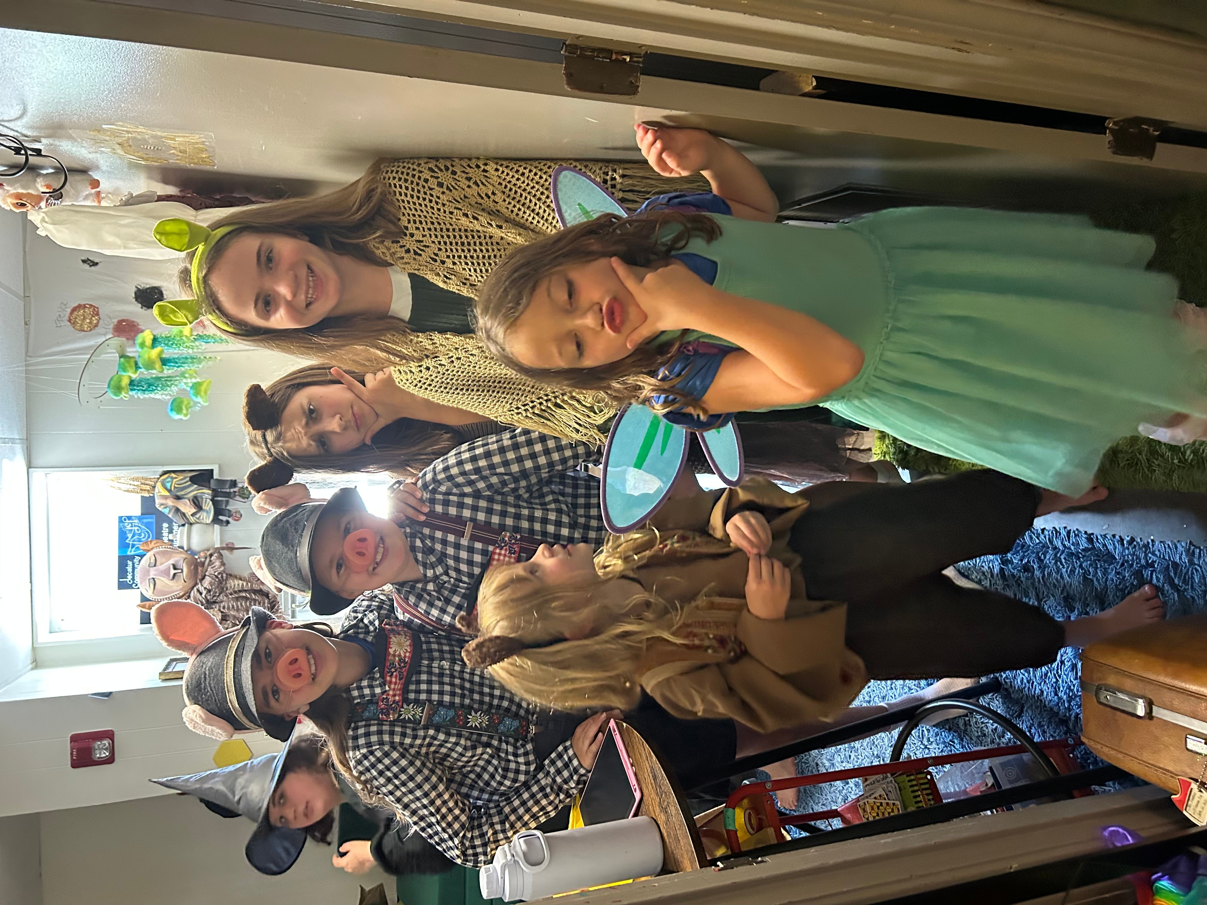 Group of people celebrating with party hats and bunny ears, some holding plates, in a room with decorations.