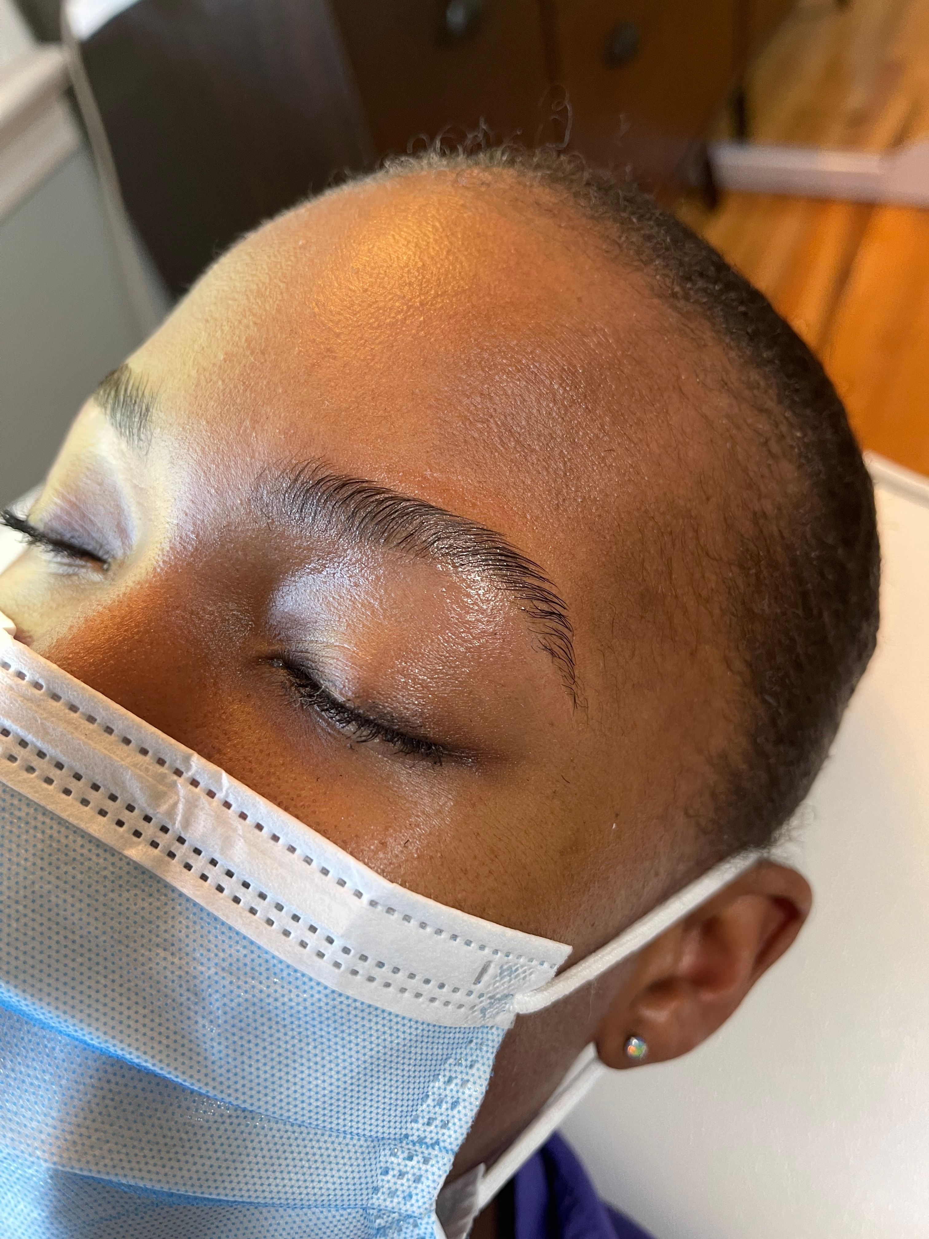 Person with short hair wearing a face mask and earrings, sleeping with eyes closed.