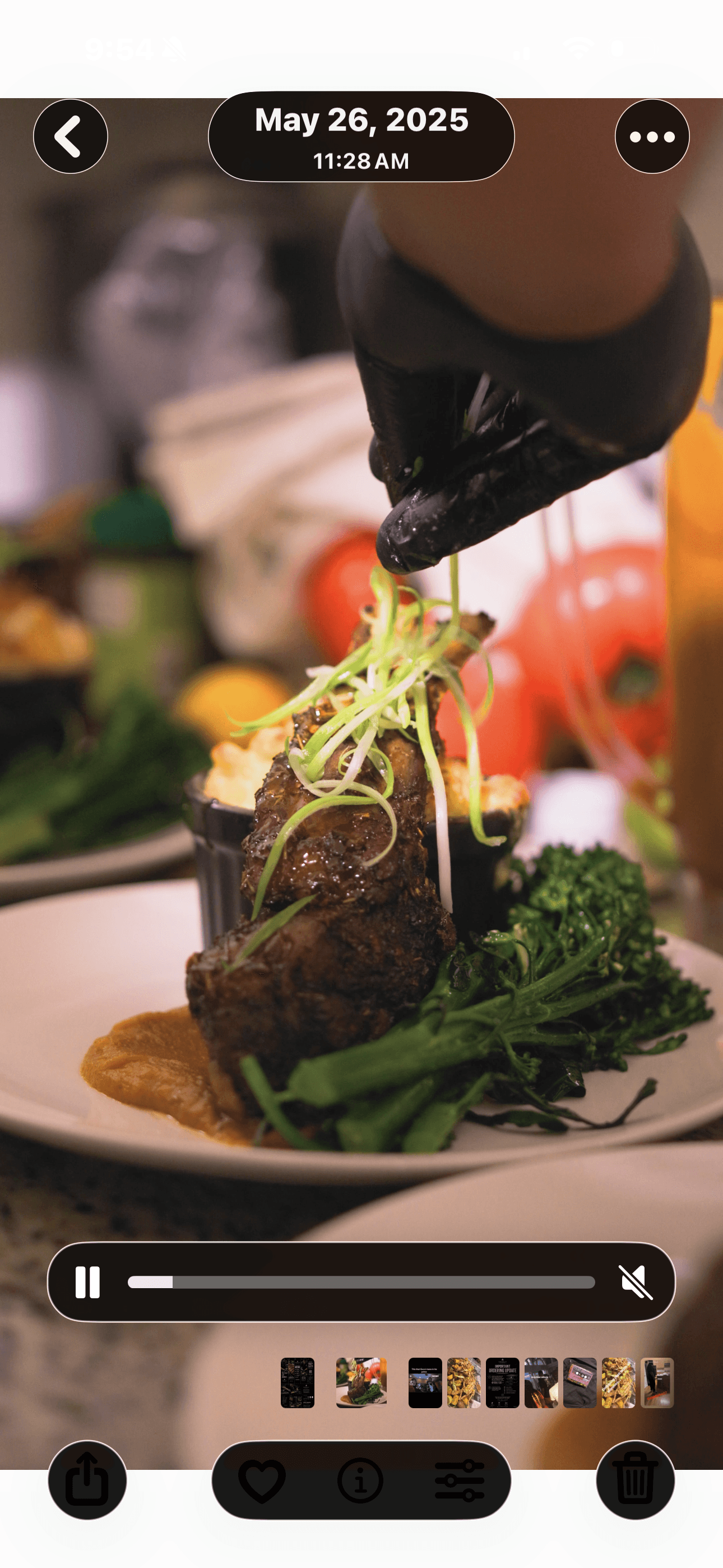 A plated dish with a piece of meat, topped with greens, and surrounded by vegetables and sauce, on a white plate.