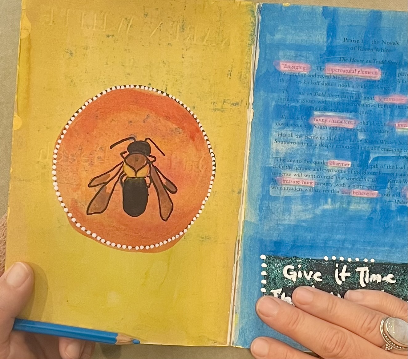Open colorful book with a bee illustration on the left page and text on the right page, held by a person's hand.