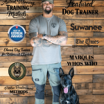 Man in gray shirt and cap with a black dog in front, wooden background with training-related text and logos.