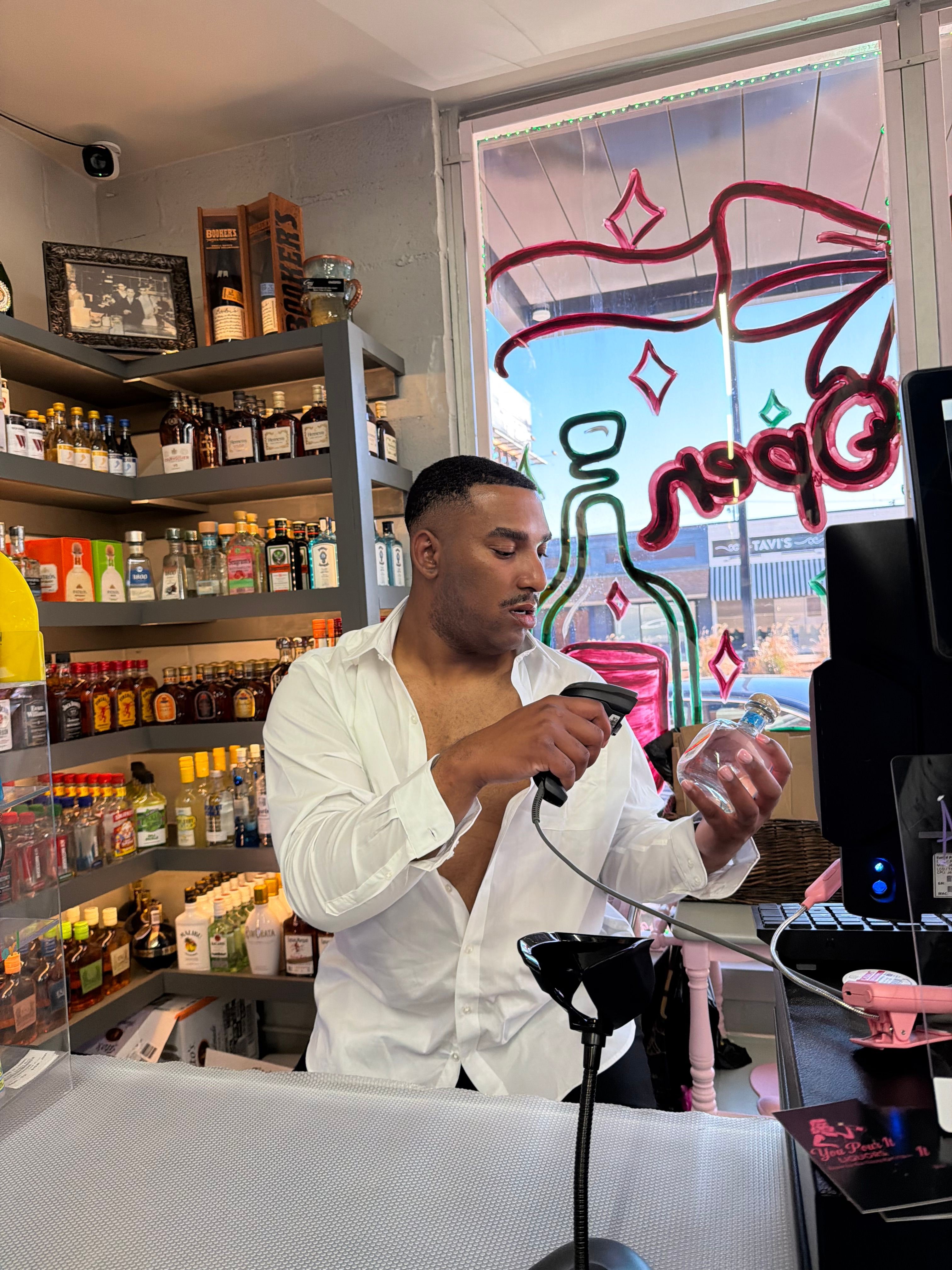 Person taking a mirror selfie in a store, holding a phone, with shelves and colorful items in the background.
