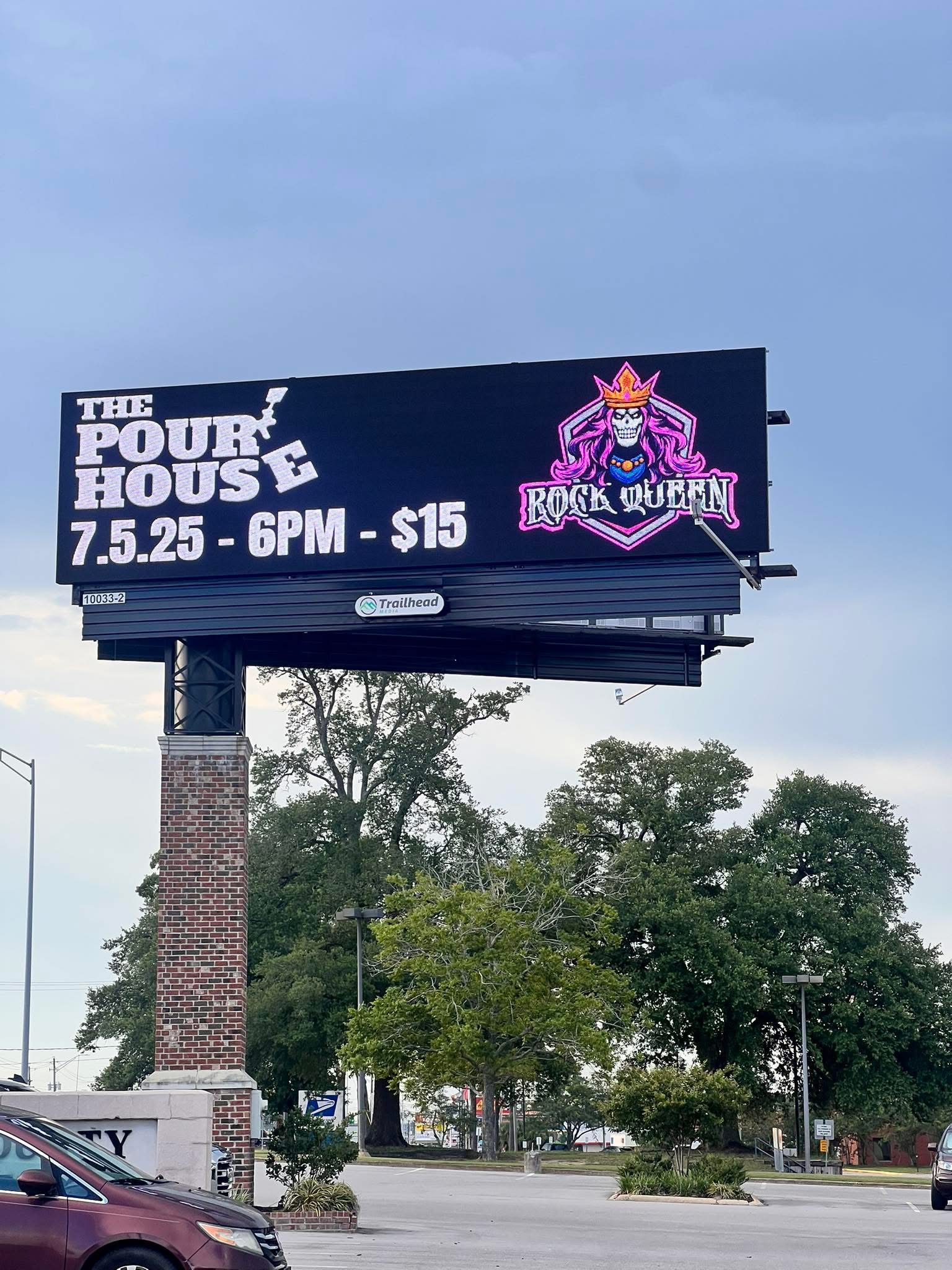 Billboard advertising a rock show event with a purple and pink logo, event date, time, and ticket price, against a cloudy sky.