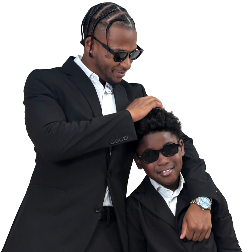 Two people, one adult and one child, both wearing sunglasses and black jackets, smiling and posing together against a black background.