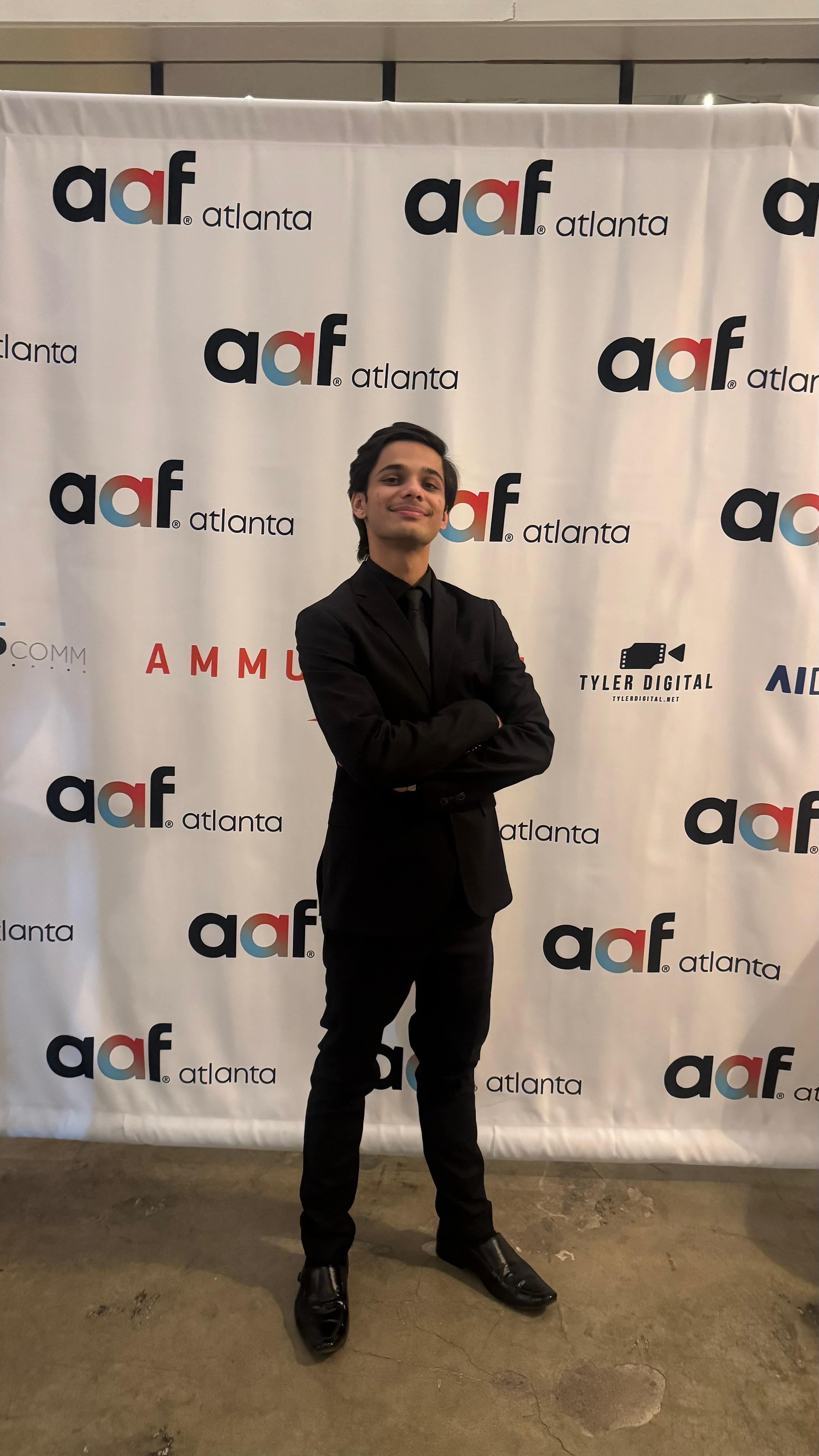 Person standing with arms crossed in front of a backdrop with 'aaf atlanta' logos.