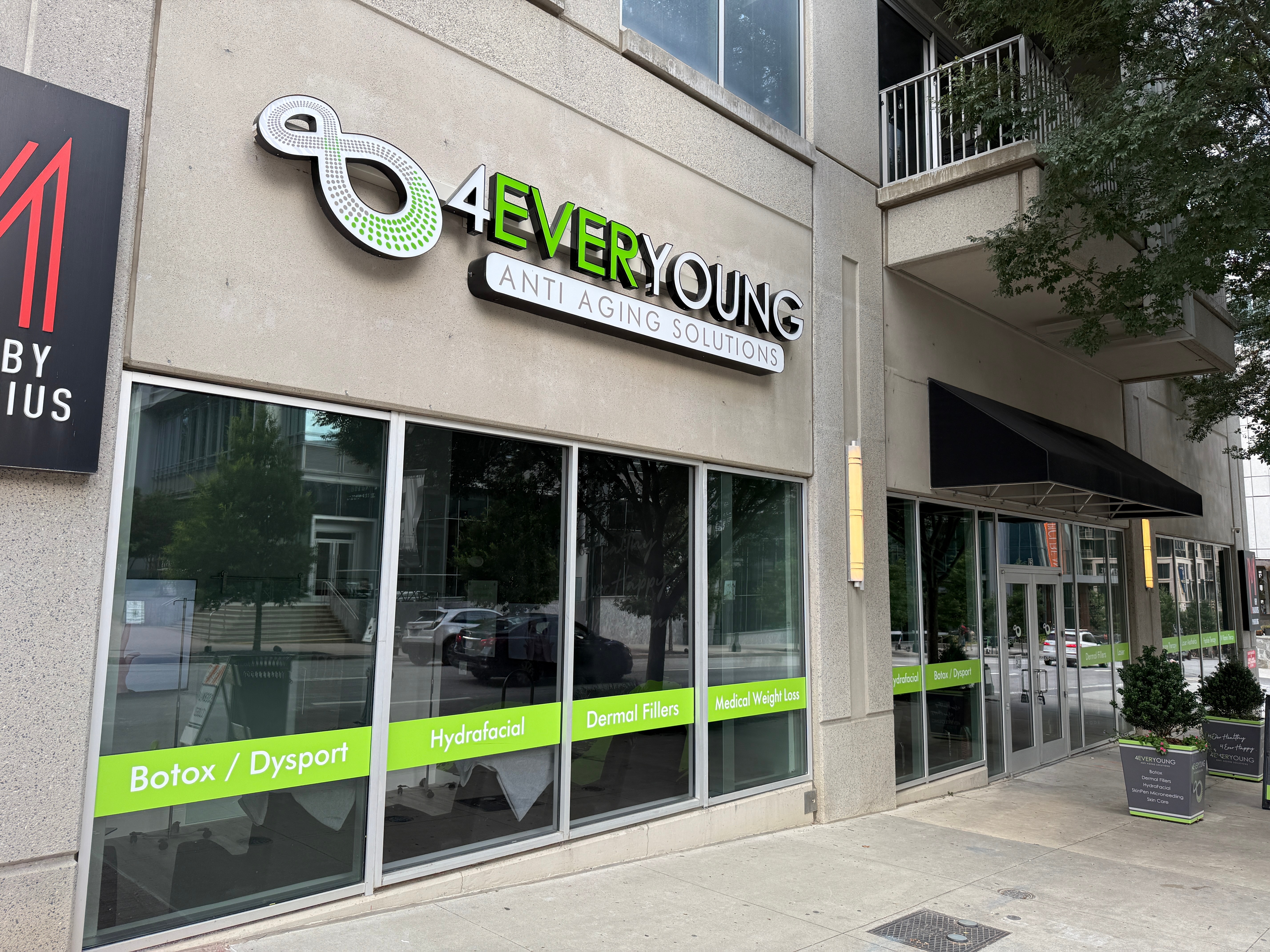 Storefront with sign reading '4EVER YOUNG' and large windows with green labels for various treatments.